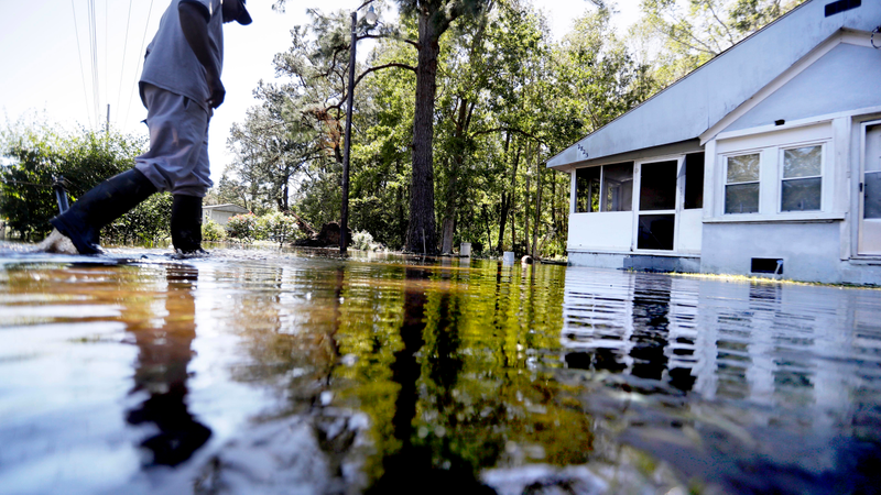Kyle Simmons wades through water to check on the home of his grandmother following Hurricane Matthew in Edisto Island, S.C., Sunday, Oct. 9, 2016. A deteriorating Matthew was stripped of hurricane status Sunday morning and began making its slow exit to the sea. (Image: AP)